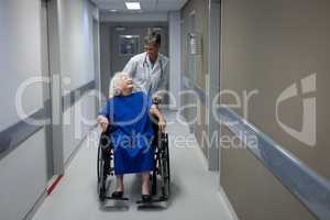 Female doctor talking with disabled senior female patient in clinic at hospital