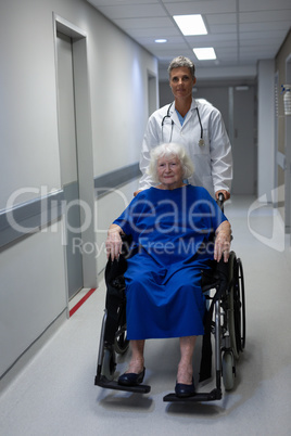 Mature female doctor and senior female patient standing in clinic