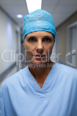 Mature female surgeon standing in hospital corridor
