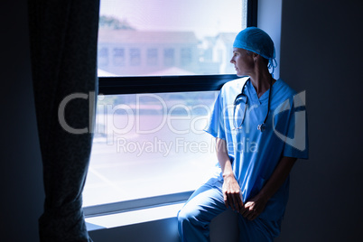 Female surgeon looking outside the through window in clinic