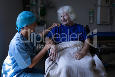 Female surgeon and senior patient talking with each other in clinic