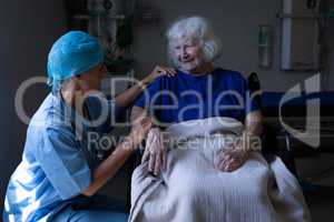 Female surgeon and senior patient talking with each other in clinic