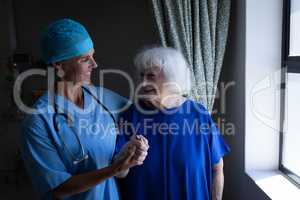 Female surgeon and senior patient talking with each other in clinic