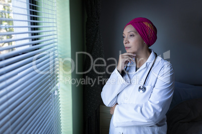 Female doctor looking outside through the window