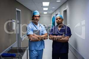 Male surgeons standing at hospital corridor