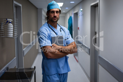 Male surgeon standing at hospital corridor