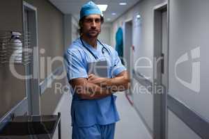 Male surgeon standing at hospital corridor