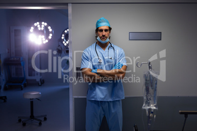 Male surgeon standing outside the operation room at hospital