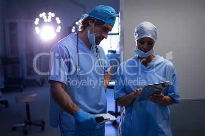 Surgeons discussing over digital tablet at hospital