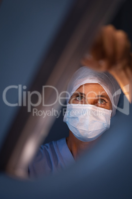 Female surgeon fixing surgical light at hospital