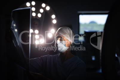 Female surgeon looking at x-ray picture in operation room