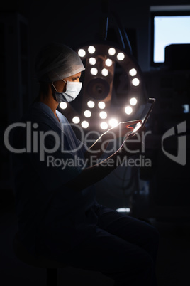 Female surgeon using a digital tablet in operation room