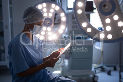 Female surgeon using a digital tablet in operation room