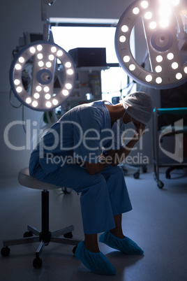 Female surgeon sitting in operation room at hospital