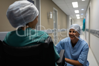 Female surgeon talking with female patient in the hospital corridor