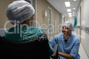 Female surgeon talking with female patient in the hospital corridor
