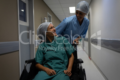 Female patient talking with female surgeon at hospital corridor