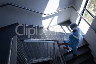 Female surgeon walking from stairs case in hospital