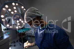 Mature female surgeon operating