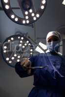 Mature female surgeon holding surgical scissor in her hand