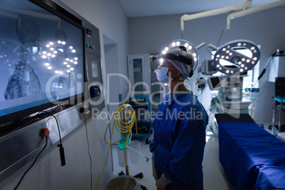 Female surgeon looking at surgical monitor in operation theater