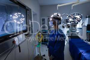 Female surgeon looking at surgical monitor in operation theater