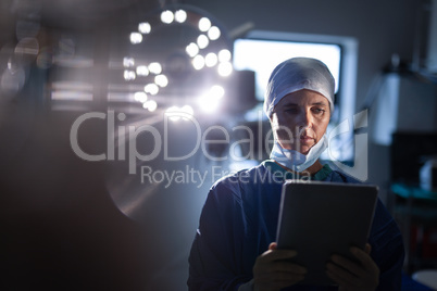 Female surgeon using digital tablet in operation room