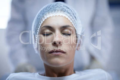 Female surgeon sitting with closed eyes on bed