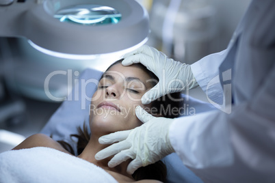 Surgeon examining patient during plastic surgery
