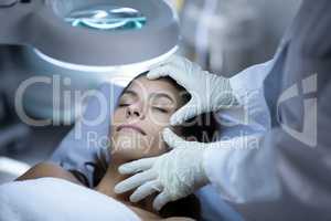 Surgeon examining patient during plastic surgery