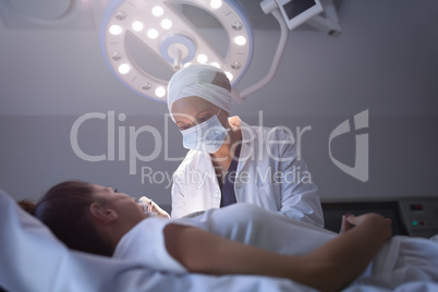 Mature female dentist checking patient with dental curing light