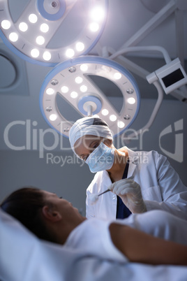 Female dentist examining patient in clinic