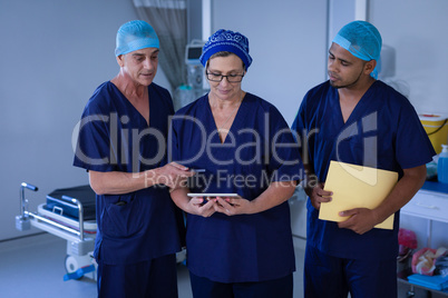 Surgeons discussing over digital tablet at hospital