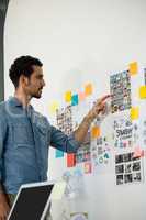 Concentrated man pointing at photographs in office