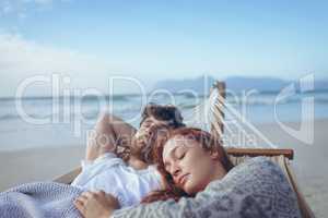 Couple sleeping on hammock at beach