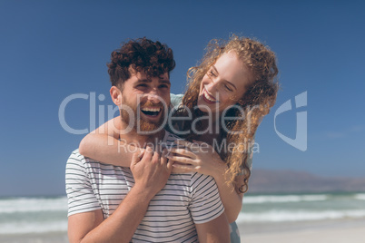 Happy couple interacting with each other at beach on a sunny day