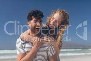 Happy couple interacting with each other at beach on a sunny day