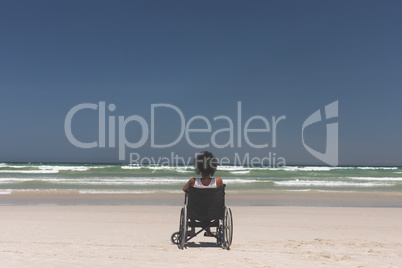 Young woman disable sitting on wheelchair at beach