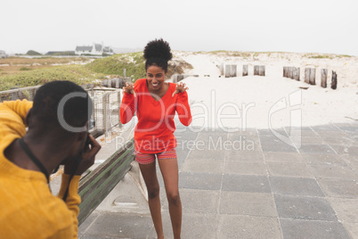 Man capturing photo of woman while standing at pavement