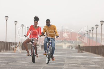 Couple riding bicycle at promenade on a sunny day