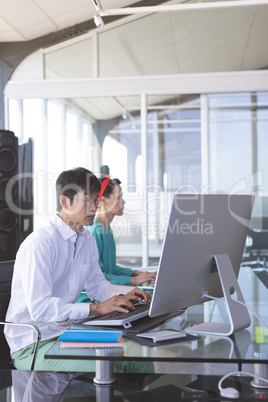 Business people working on computer at desk in office