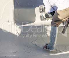 Worker Wearing Spiked Shoes Smoothing Wet Pool Plaster With Trowel