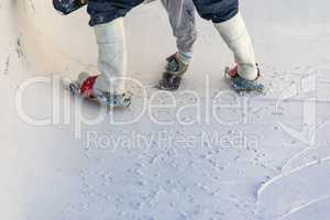 Worker Wearing Spiked Shoes Smoothing Wet Pool Plaster With Trowel