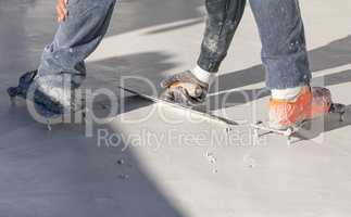 Worker Wearing Spiked Shoes Smoothing Wet Pool Plaster With Trowel