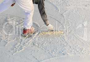 Worker Wearing Spiked Shoes Smoothing Wet Pool Plaster With Trowel