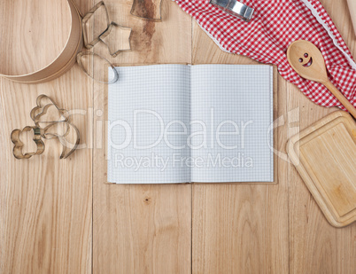 blank open notebook in line and wooden kitchen accessories