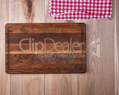 Empty old wooden kitchen cutting board and a red towel