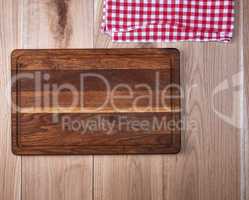 Empty old wooden kitchen cutting board and a red towel