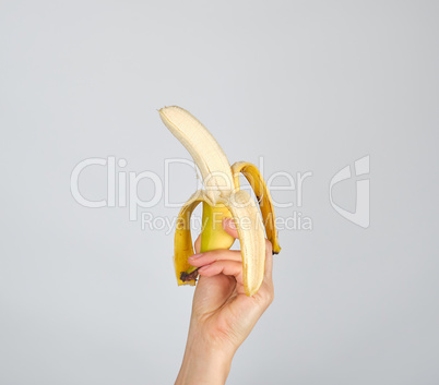 peeled fresh banana in female hand