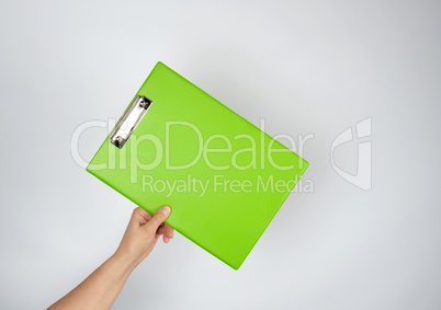 female hand holding a green tablet for clamping papers